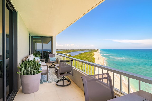 balcony with a water view and a beach view