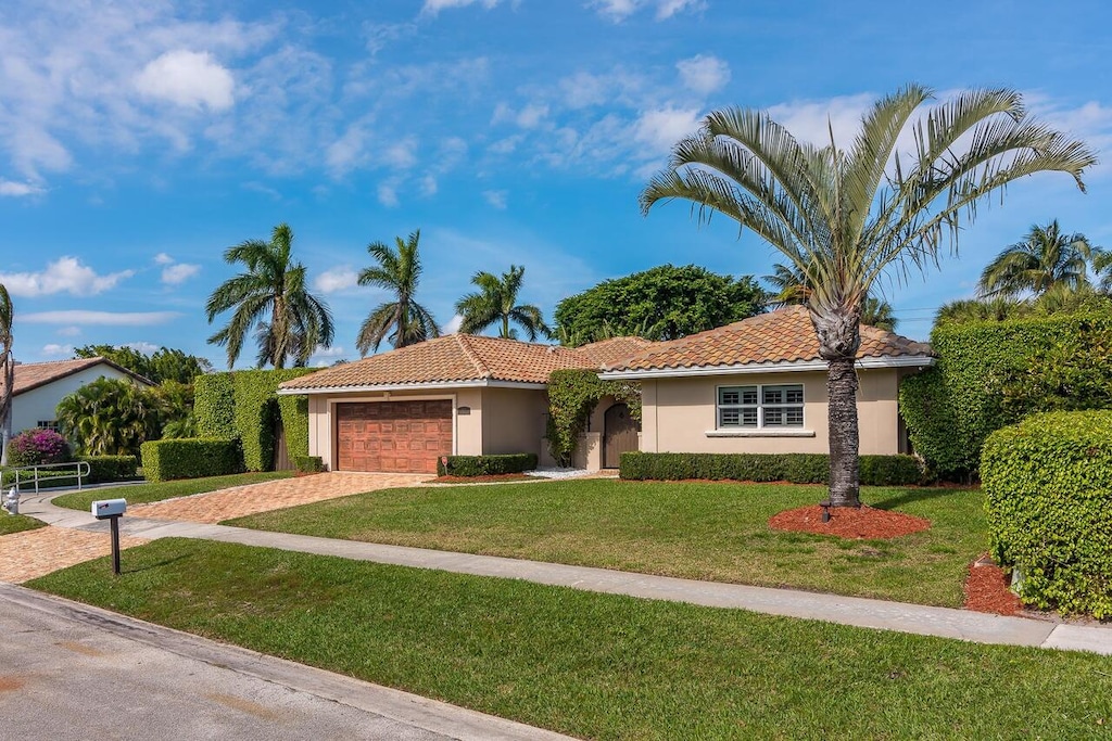 view of front facade featuring a garage and a front lawn