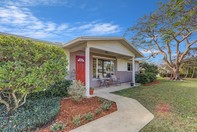 view of exterior entry with a lawn