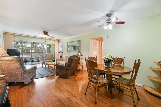 dining area with wood-type flooring, ornamental molding, and ceiling fan