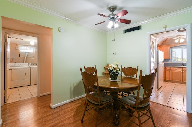 dining room featuring sink, crown molding, light hardwood / wood-style flooring, ceiling fan, and independent washer and dryer