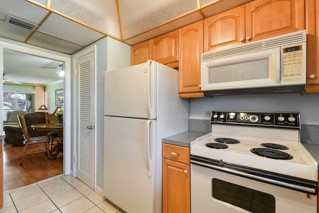 kitchen featuring ceiling fan, light tile patterned floors, and white appliances