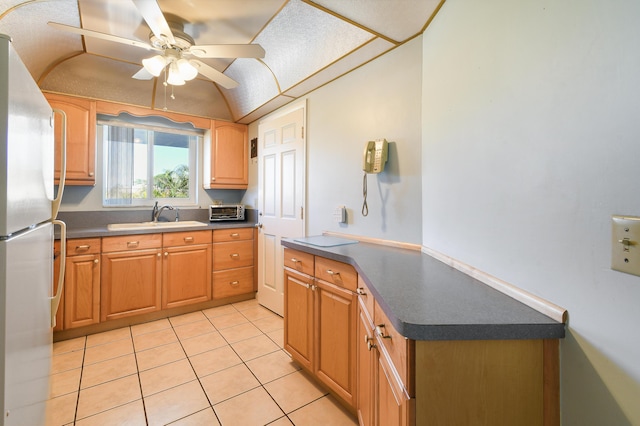 kitchen featuring sink, light tile patterned floors, stainless steel fridge, and ceiling fan