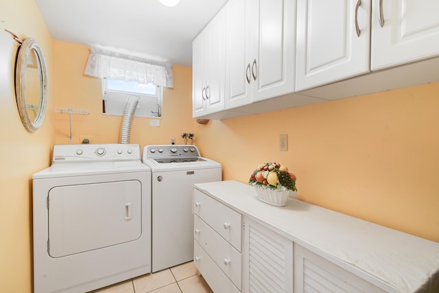 washroom featuring washer and dryer, cabinets, and light tile patterned flooring