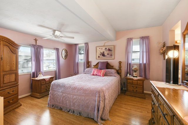 bedroom featuring multiple windows, beam ceiling, light hardwood / wood-style floors, and ceiling fan