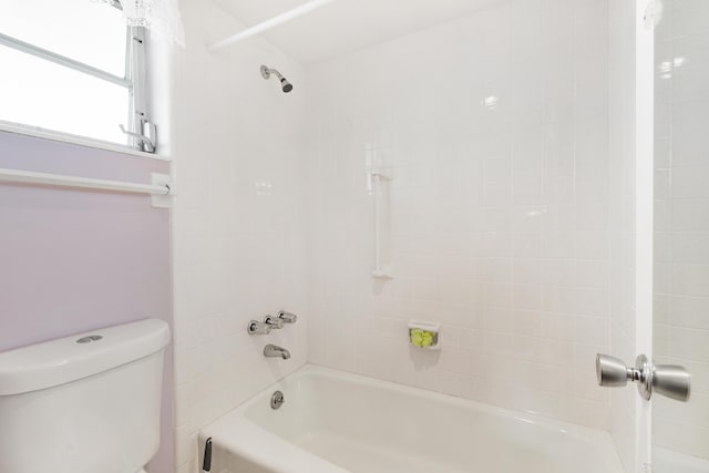 bathroom featuring tiled shower / bath and toilet