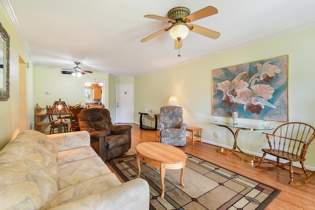 living room with ceiling fan, ornamental molding, and wood-type flooring