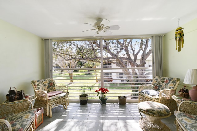 living area featuring ceiling fan, light tile patterned floors, and a wall of windows