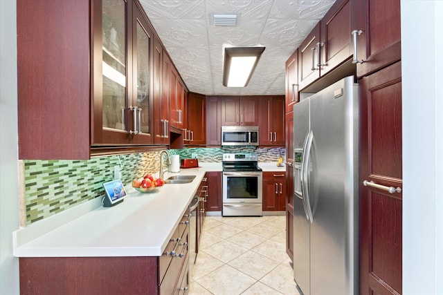 kitchen featuring appliances with stainless steel finishes, sink, decorative backsplash, and light tile patterned floors