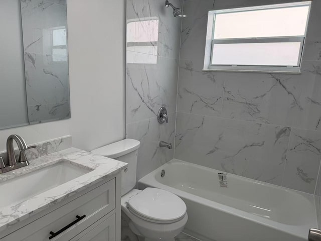 full bathroom with tiled shower / bath, vanity, and toilet