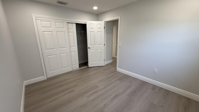 unfurnished bedroom featuring light hardwood / wood-style floors and a closet