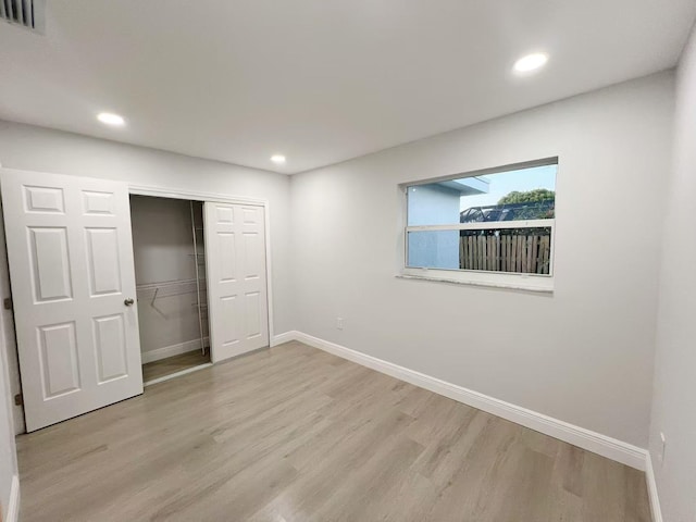 unfurnished bedroom with light hardwood / wood-style flooring and a closet