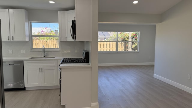 kitchen with white cabinetry, dishwasher, and sink