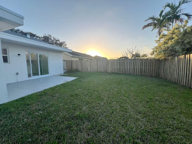 yard at dusk featuring a patio