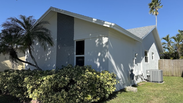 view of side of property with a yard and central AC unit