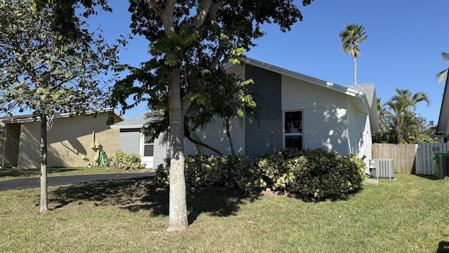 view of home's exterior with a lawn and central air condition unit