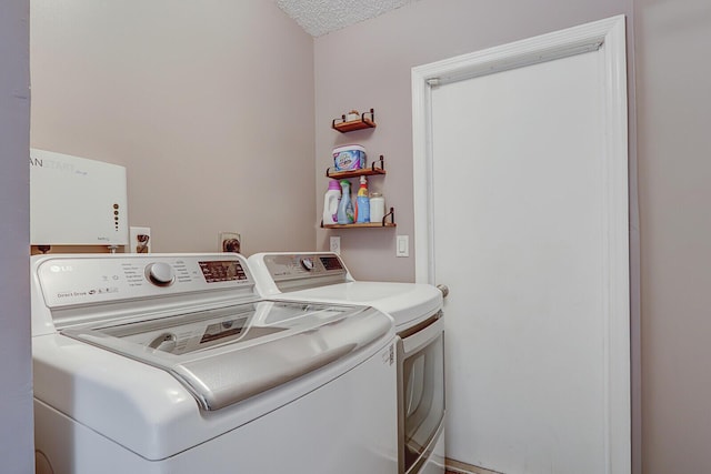 washroom featuring washing machine and dryer and a textured ceiling