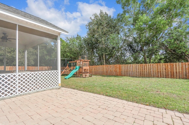 view of patio with ceiling fan, a sunroom, and a playground