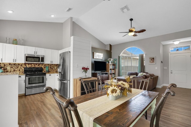 dining space featuring high vaulted ceiling, ceiling fan, and light hardwood / wood-style flooring