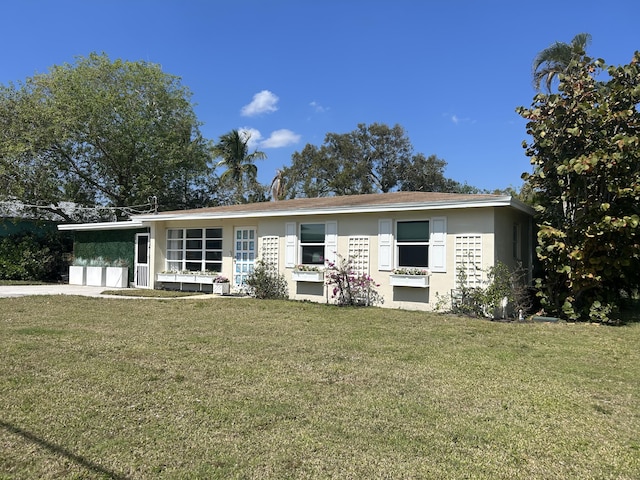 ranch-style house with a garage, a front lawn, and stucco siding