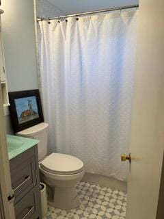 bathroom featuring vanity, toilet, and walk in shower