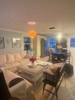 living room with ornamental molding and visible vents