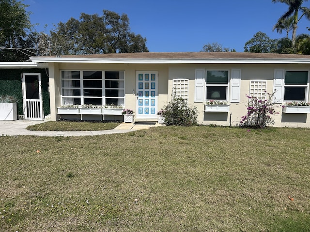 view of front of house featuring stucco siding and a front yard