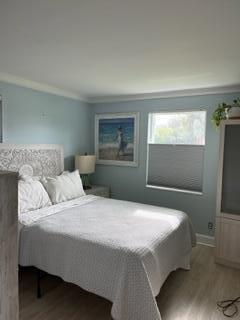 bedroom featuring hardwood / wood-style flooring and crown molding