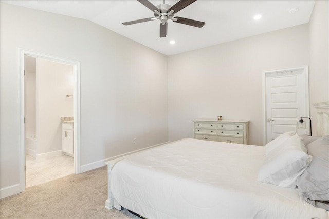 bedroom featuring ceiling fan, lofted ceiling, light carpet, and ensuite bath