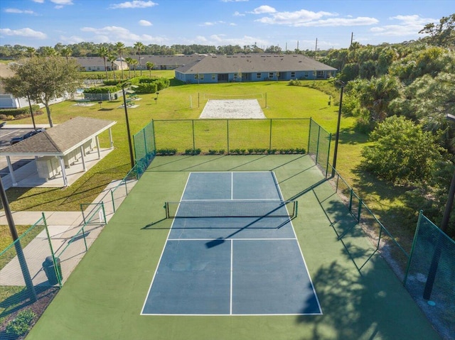 view of tennis court featuring a lawn