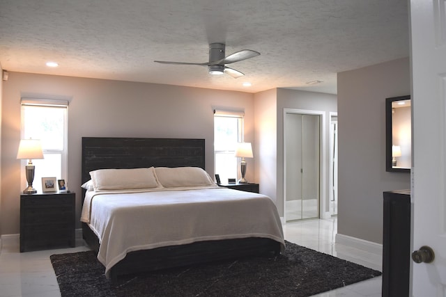 bedroom featuring ceiling fan and a textured ceiling