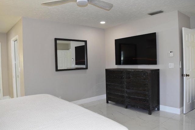 bedroom featuring ceiling fan and a textured ceiling