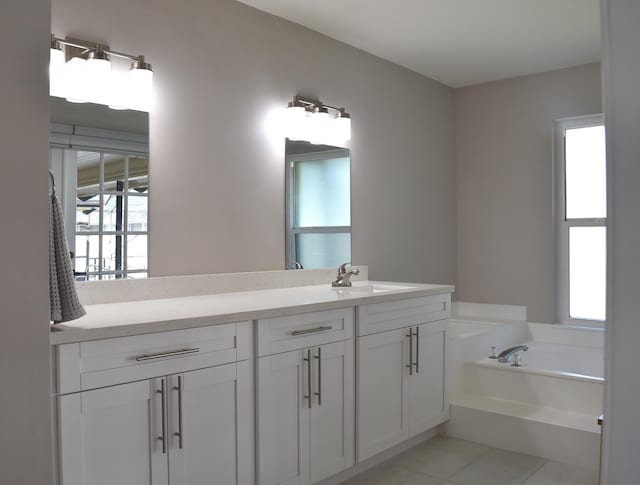 bathroom with vanity, a wealth of natural light, tile patterned floors, and a tub