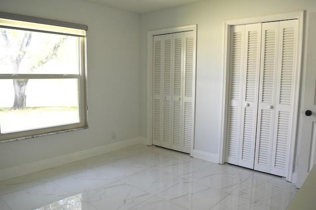 unfurnished bedroom featuring multiple closets and multiple windows