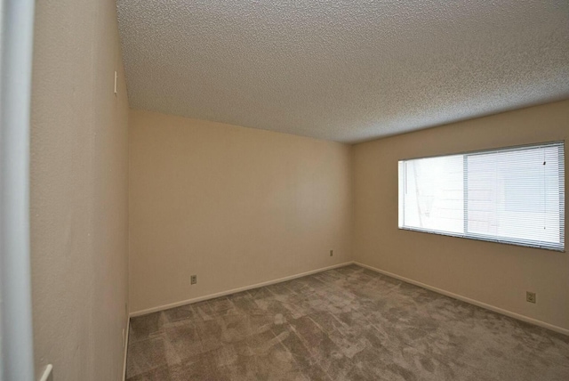 carpeted spare room featuring a textured ceiling