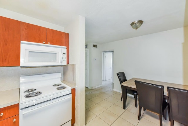 kitchen with light tile patterned flooring and white appliances