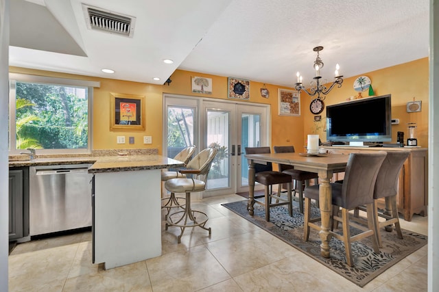 dining room featuring french doors, light tile patterned flooring, a textured ceiling, and a notable chandelier