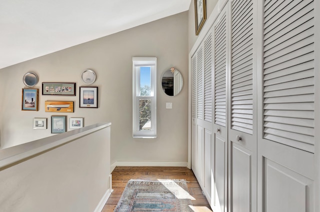 hallway featuring lofted ceiling and light hardwood / wood-style floors