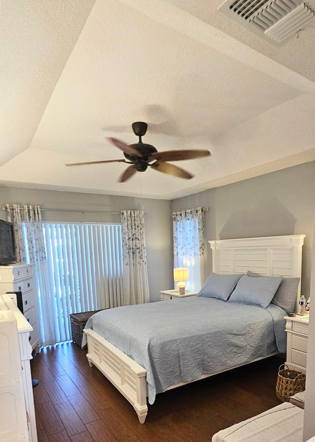 bedroom featuring dark hardwood / wood-style flooring, a textured ceiling, and ceiling fan