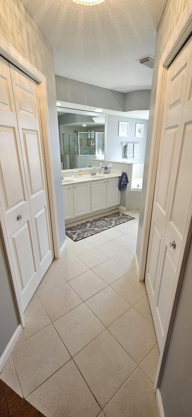 bathroom with vanity, tile patterned flooring, and a textured ceiling