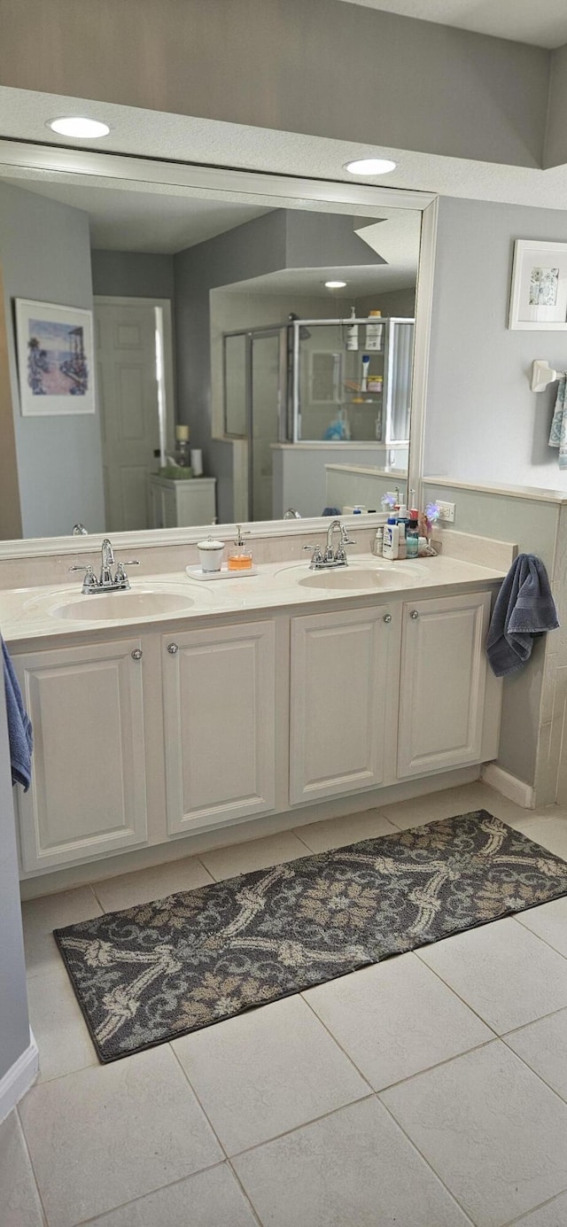 bathroom featuring vanity, a shower with door, and tile patterned floors