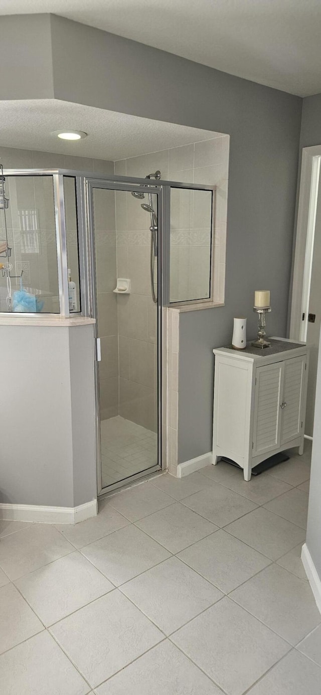 bathroom with tile patterned flooring and a shower with door