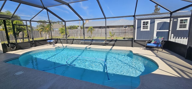 view of pool with a shed, a lanai, and a patio area