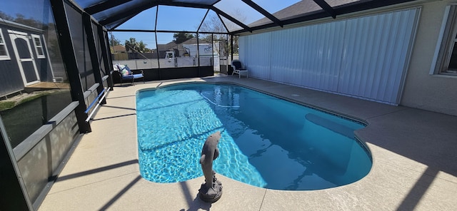 view of swimming pool featuring glass enclosure and a patio area