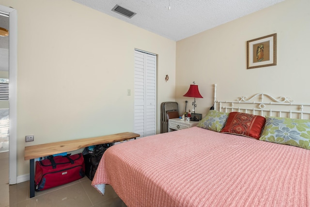 tiled bedroom with a textured ceiling