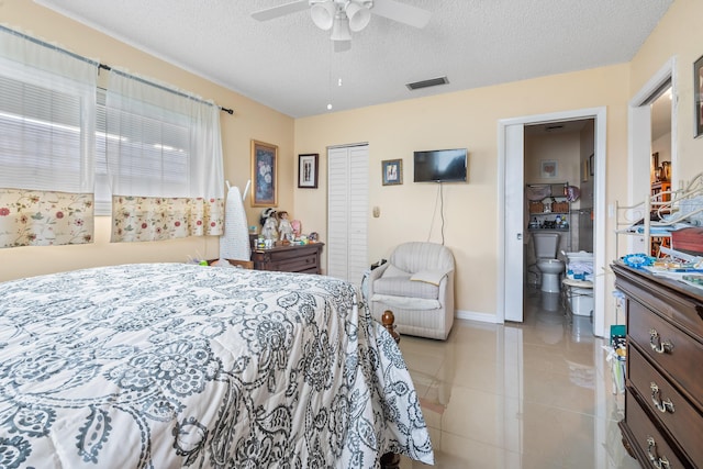 tiled bedroom featuring ceiling fan, a closet, and a textured ceiling