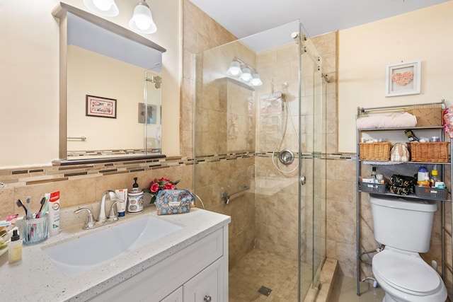 bathroom featuring walk in shower, tile walls, vanity, and toilet