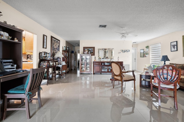 living room featuring light tile patterned floors, a textured ceiling, and ceiling fan