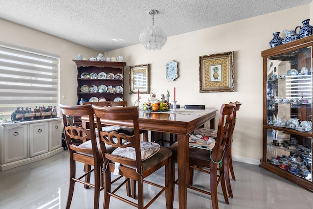 tiled dining space featuring a textured ceiling