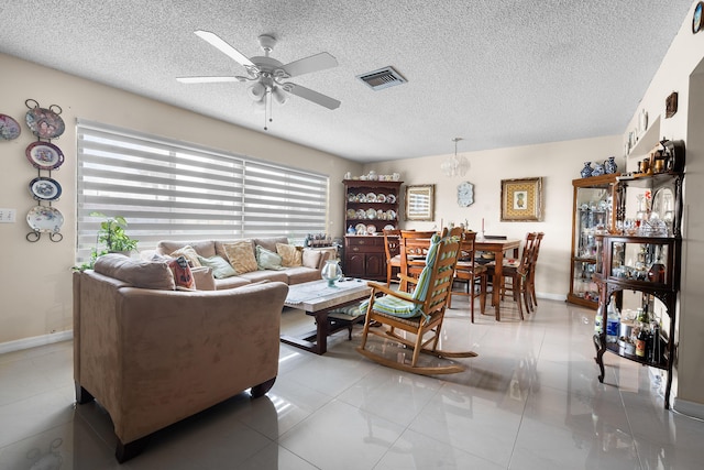 living room with light tile patterned floors, a textured ceiling, and ceiling fan